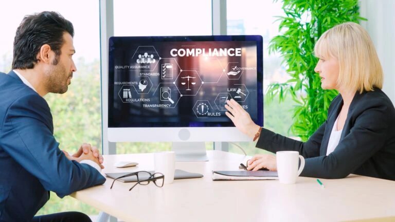 a man and a woman having a meeting about compliance