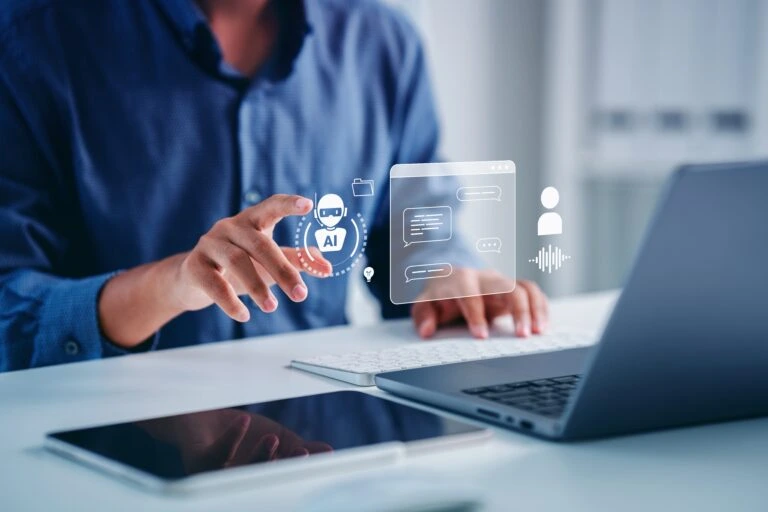 A man pointing at a hologram above his laptop